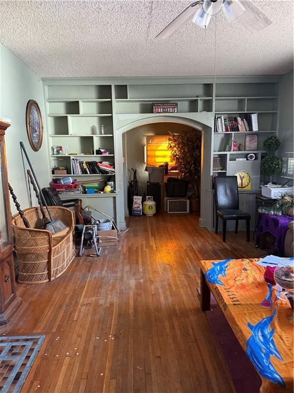 interior space featuring hardwood / wood-style floors, ceiling fan, and a textured ceiling