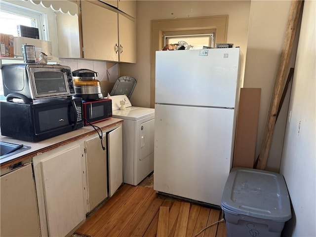 kitchen featuring white cabinetry, white fridge, light hardwood / wood-style floors, and washer / dryer