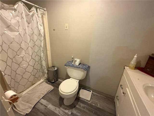 bathroom with hardwood / wood-style flooring, vanity, and toilet