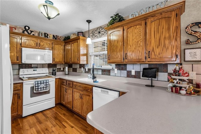 kitchen featuring sink, dark hardwood / wood-style floors, pendant lighting, a textured ceiling, and white appliances