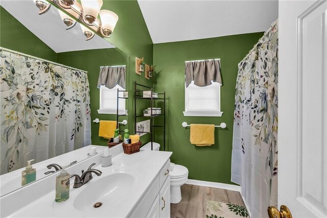 bathroom with vanity, lofted ceiling, toilet, a notable chandelier, and wood-type flooring