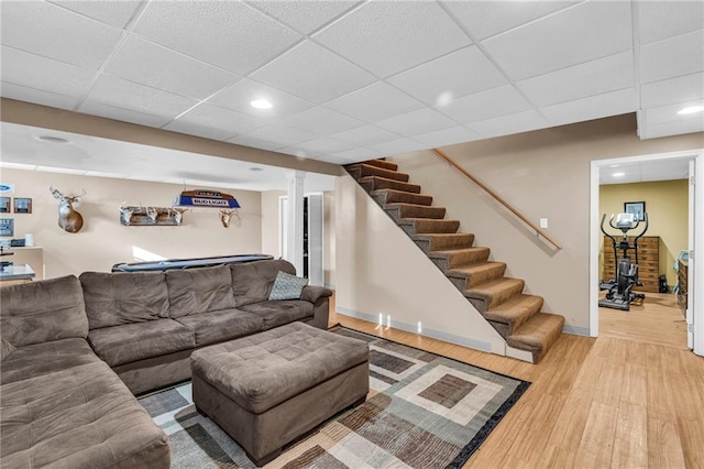 living room featuring a drop ceiling and wood-type flooring