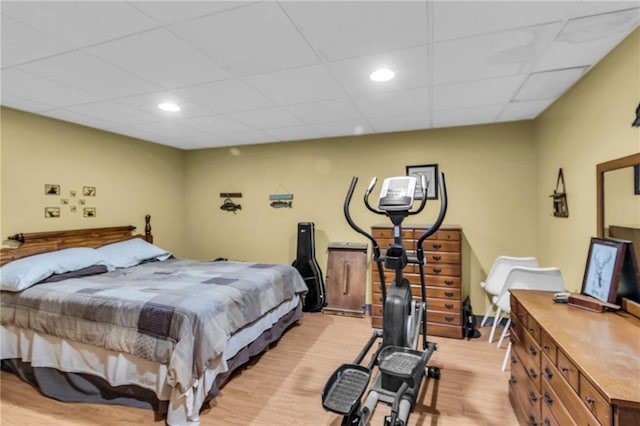 bedroom featuring light hardwood / wood-style flooring and a drop ceiling