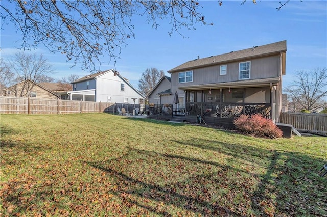 back of property with a sunroom and a lawn