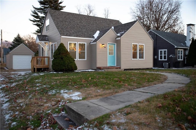 view of front of house with a front lawn, central AC unit, an outdoor structure, and a garage