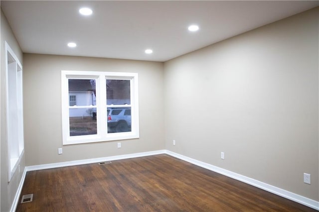 unfurnished room featuring dark hardwood / wood-style flooring and a wealth of natural light