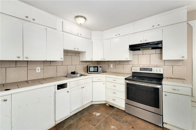 kitchen featuring white cabinets, stainless steel appliances, decorative backsplash, and sink