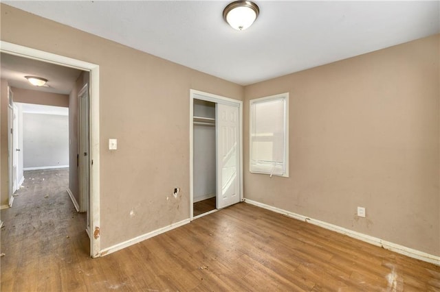 unfurnished bedroom featuring wood-type flooring and a closet