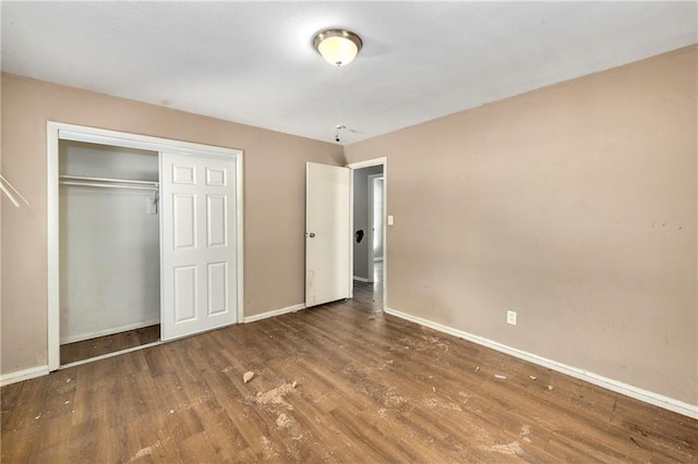 unfurnished bedroom with dark wood-type flooring and a closet