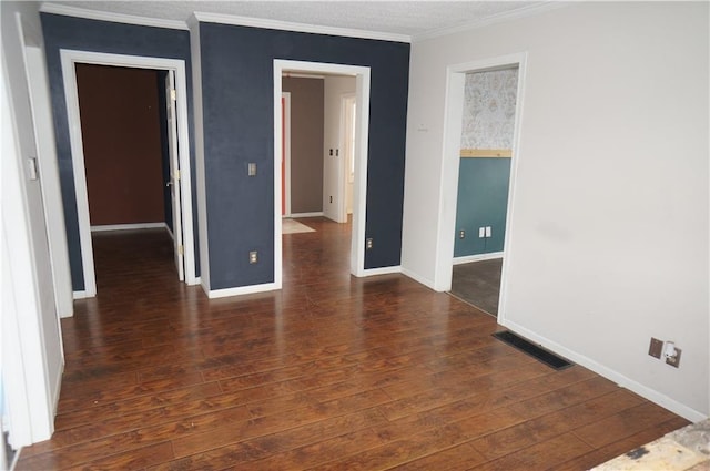 empty room with ornamental molding and dark wood-type flooring