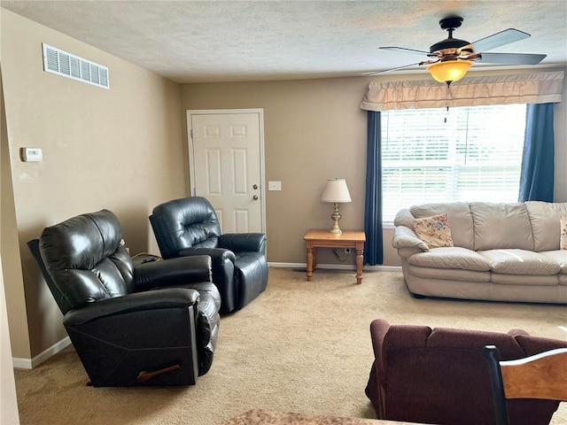 carpeted living room with ceiling fan and a textured ceiling