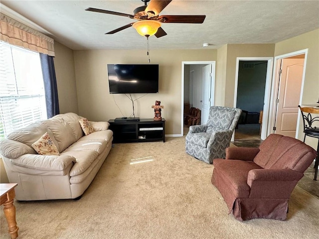 carpeted living room with ceiling fan