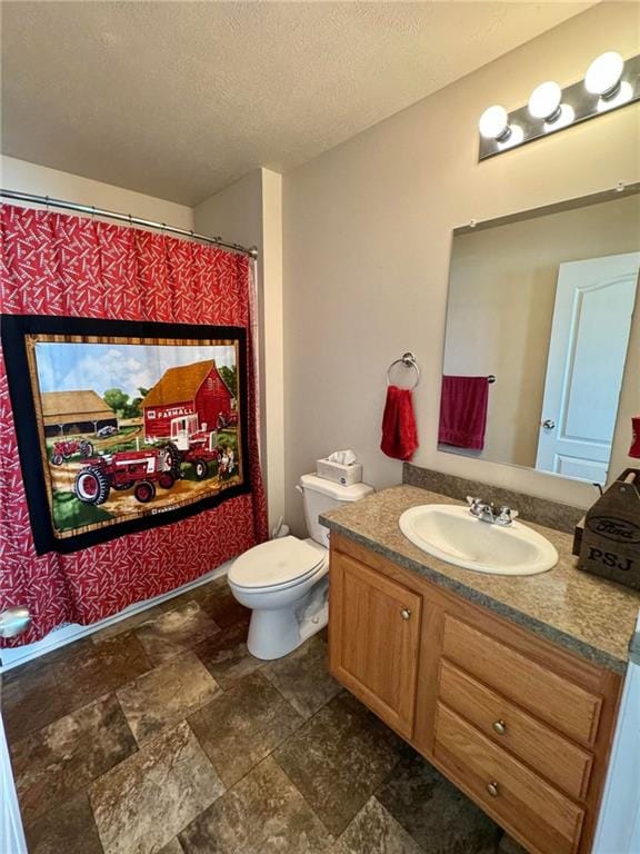 bathroom featuring vanity, a textured ceiling, and toilet