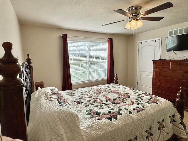 bedroom with ceiling fan and a textured ceiling