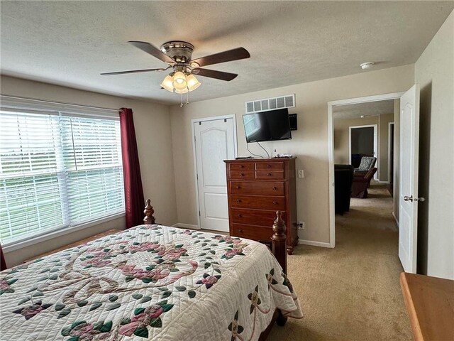 carpeted bedroom with a textured ceiling and ceiling fan