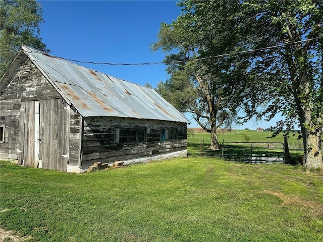 view of outbuilding with a rural view and a lawn