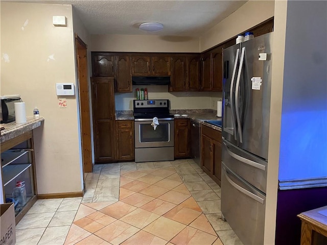 kitchen featuring dark brown cabinetry, light tile patterned floors, a textured ceiling, and appliances with stainless steel finishes