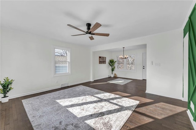 unfurnished room with ceiling fan with notable chandelier and dark hardwood / wood-style flooring