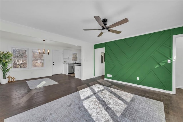 unfurnished living room featuring dark hardwood / wood-style flooring and ceiling fan with notable chandelier