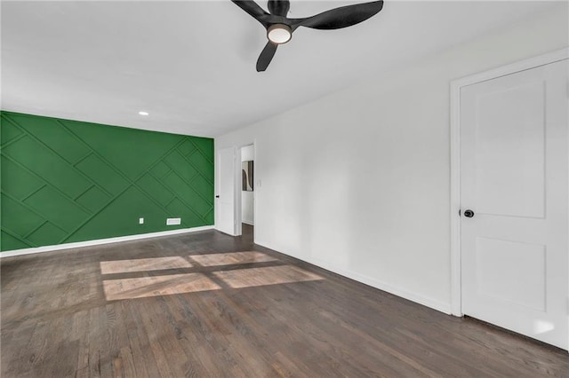 spare room with dark hardwood / wood-style flooring and ceiling fan