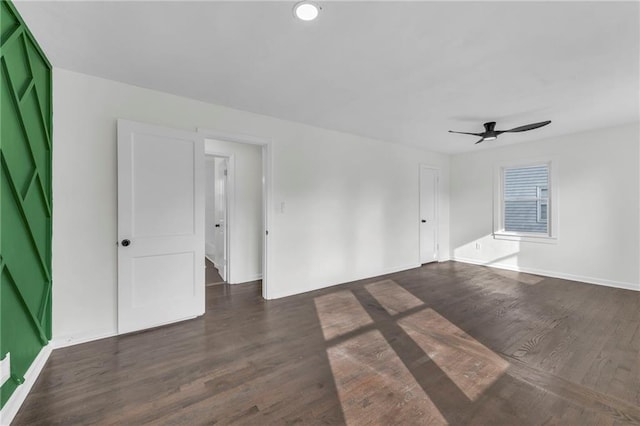 spare room with dark hardwood / wood-style floors and ceiling fan