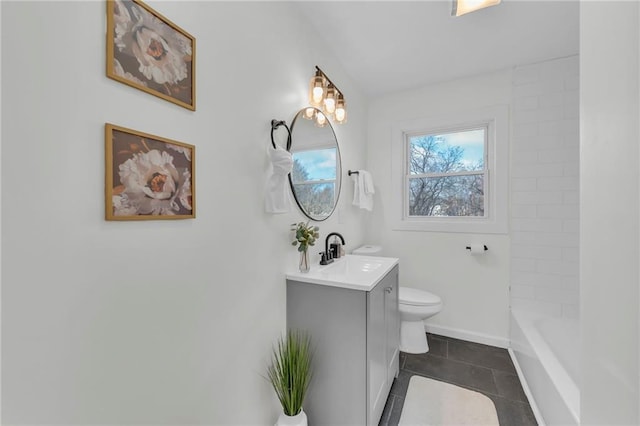 bathroom with tile patterned floors, vanity, toilet, and a tub