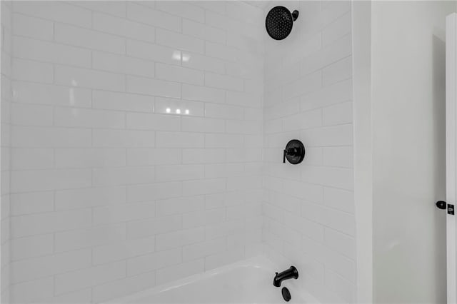 interior details with tiled shower / bath combo