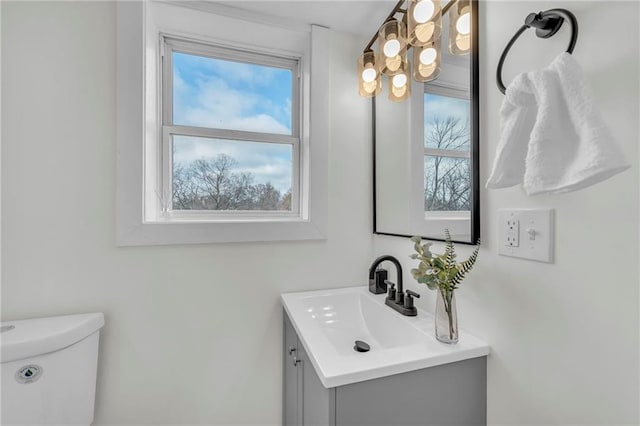 bathroom with plenty of natural light, vanity, and toilet