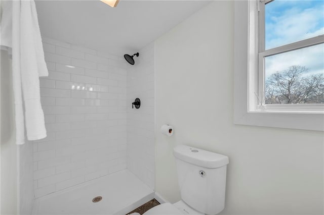 bathroom with tiled shower and toilet