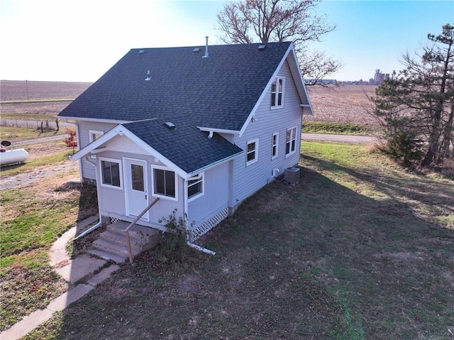 exterior space with a rural view, a lawn, and central air condition unit