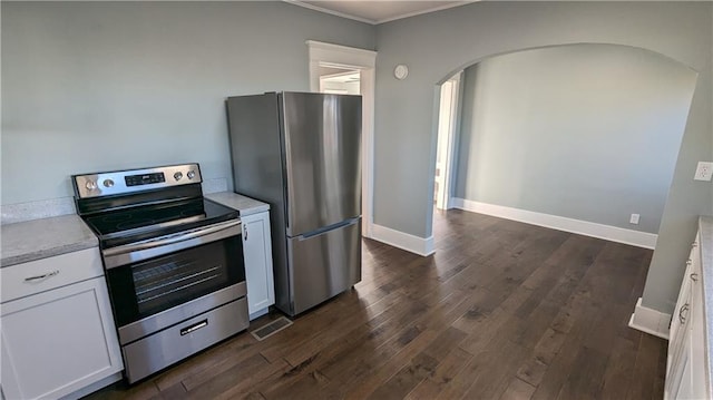 kitchen featuring white cabinets, crown molding, dark hardwood / wood-style flooring, and stainless steel appliances