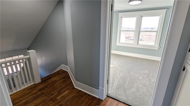 stairway featuring lofted ceiling and wood-type flooring