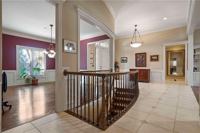 hallway with crown molding, light tile patterned flooring, and an inviting chandelier