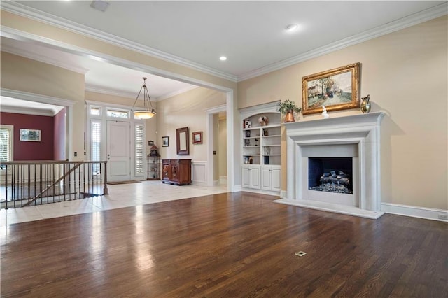 unfurnished living room with crown molding, hardwood / wood-style floors, and built in shelves