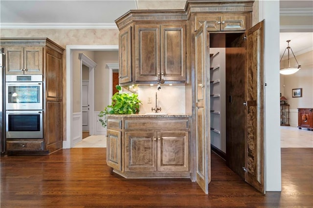 kitchen with sink, crown molding, dark hardwood / wood-style floors, and stainless steel double oven