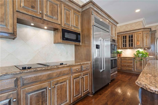 kitchen featuring ornamental molding, light stone countertops, dark hardwood / wood-style floors, and black appliances