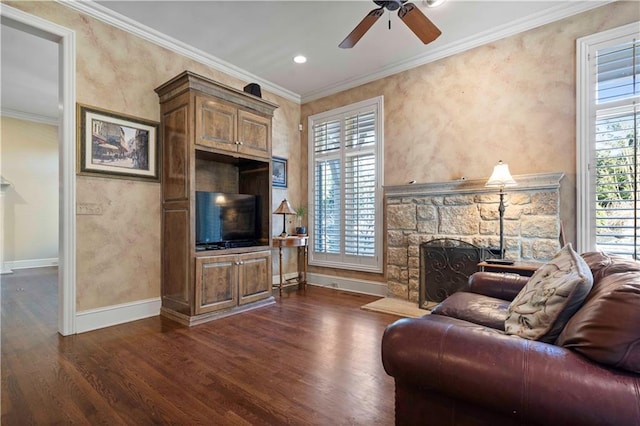 living room featuring dark wood-type flooring, ceiling fan, ornamental molding, and a fireplace