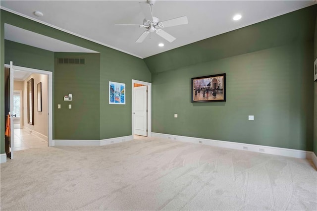 empty room with ceiling fan, light colored carpet, and vaulted ceiling