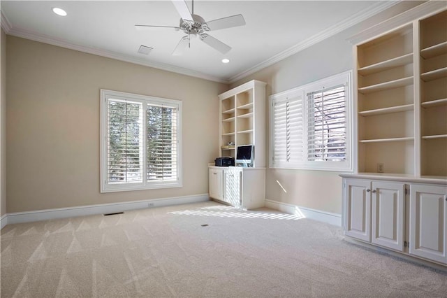 unfurnished office with ornamental molding, plenty of natural light, light colored carpet, and ceiling fan