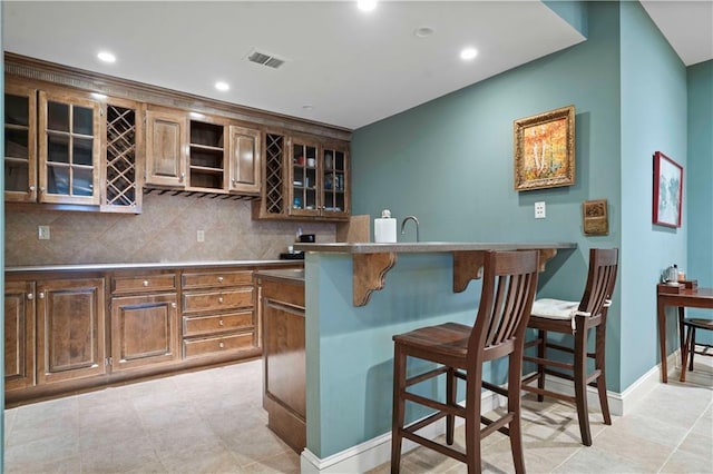 kitchen featuring sink, backsplash, and a kitchen breakfast bar