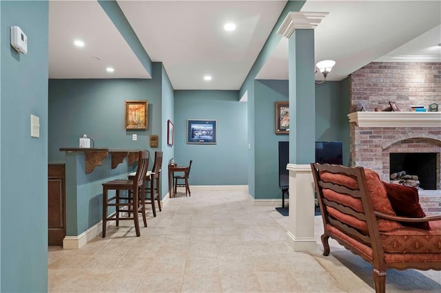 interior space with ornate columns and a brick fireplace