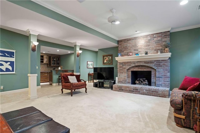 carpeted living room featuring crown molding, indoor bar, a fireplace, and decorative columns