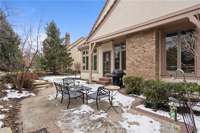 snow covered patio featuring grilling area