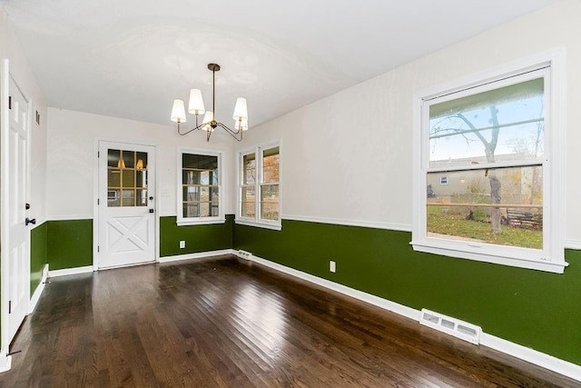 unfurnished dining area with wood-type flooring and a notable chandelier