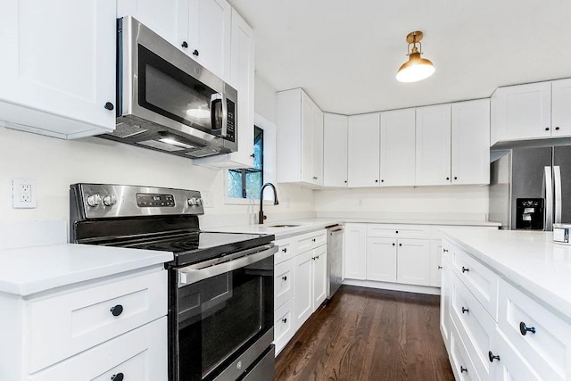 kitchen featuring dark hardwood / wood-style flooring, sink, white cabinetry, and stainless steel appliances