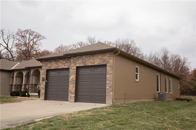 view of side of property with a yard and central AC