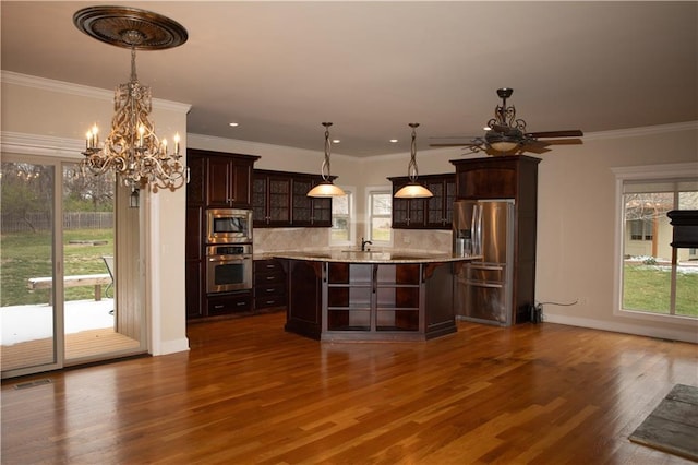 bar featuring dark hardwood / wood-style flooring, tasteful backsplash, dark brown cabinetry, stainless steel appliances, and decorative light fixtures