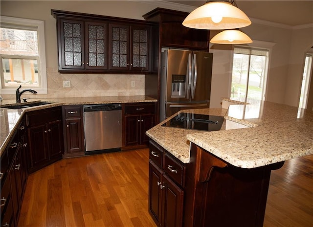 kitchen featuring sink, a breakfast bar area, a wealth of natural light, decorative light fixtures, and stainless steel appliances