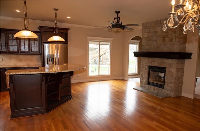 kitchen with stainless steel fridge with ice dispenser, dark brown cabinetry, and light hardwood / wood-style flooring