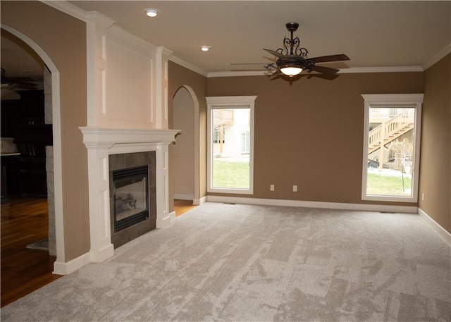 unfurnished living room featuring a fireplace, a healthy amount of sunlight, and crown molding